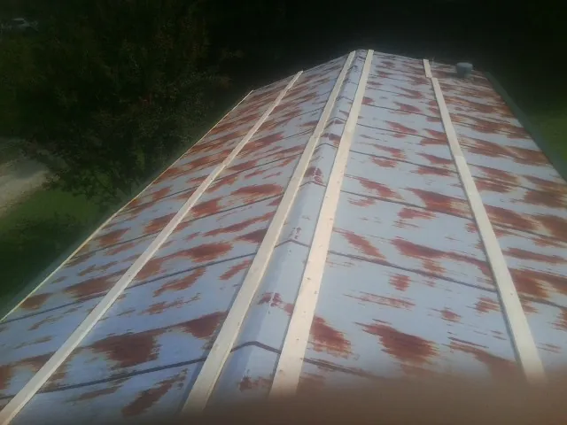Rusted metal roof panels with new wood purlins before replacement — Storm Damage Roof Repair in Belle Rose by Roofing Brothers