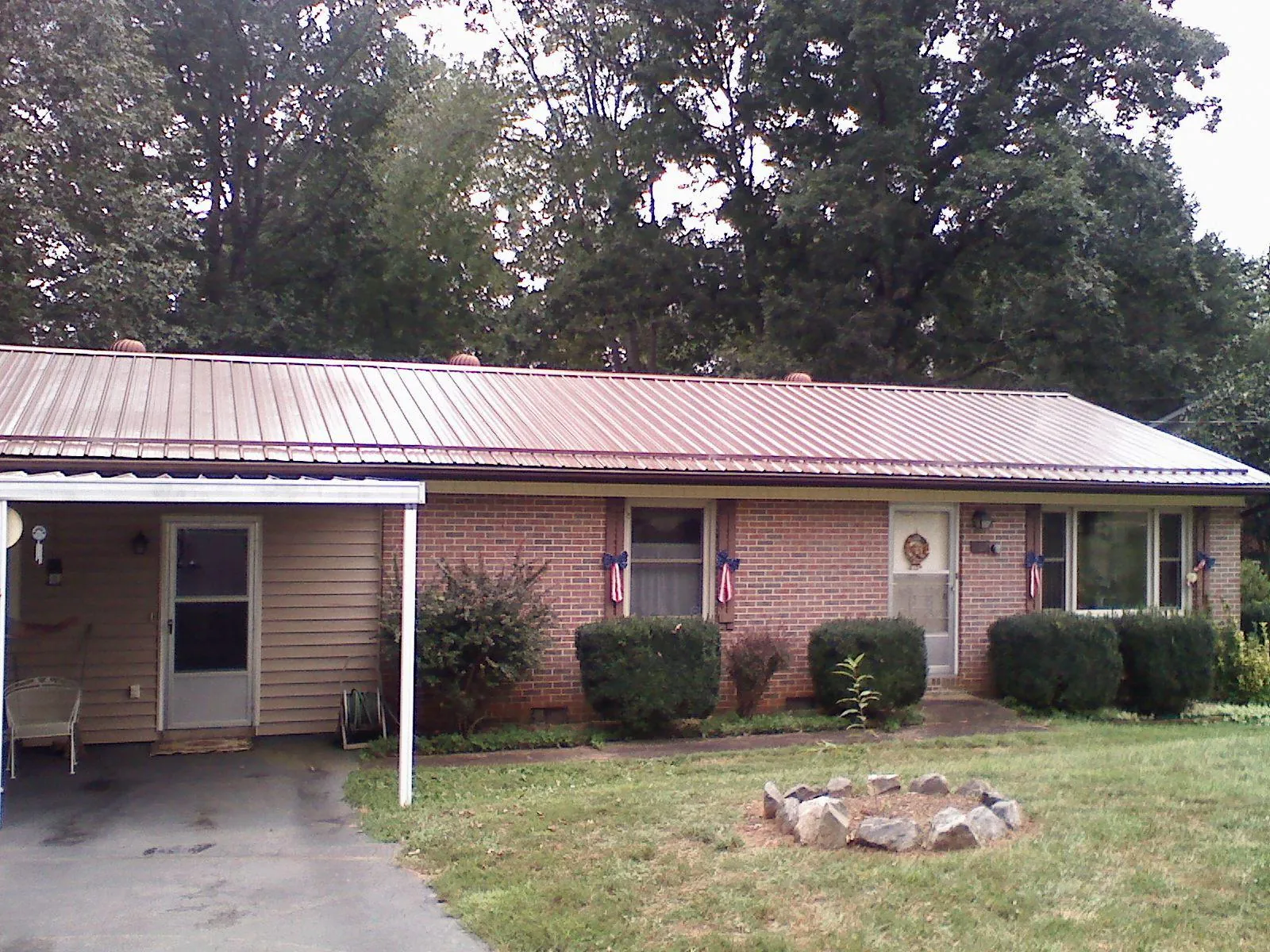 Bronze metal roof and carport on a brick ranch home — Roof Repair work by our crew in Belle Rose